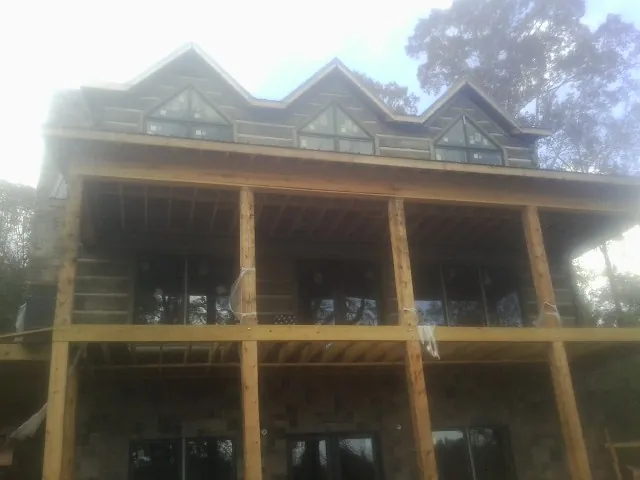 Dormers and porch framing on a large log home under construction — Roof Coating work by our crew in Dunsmuir