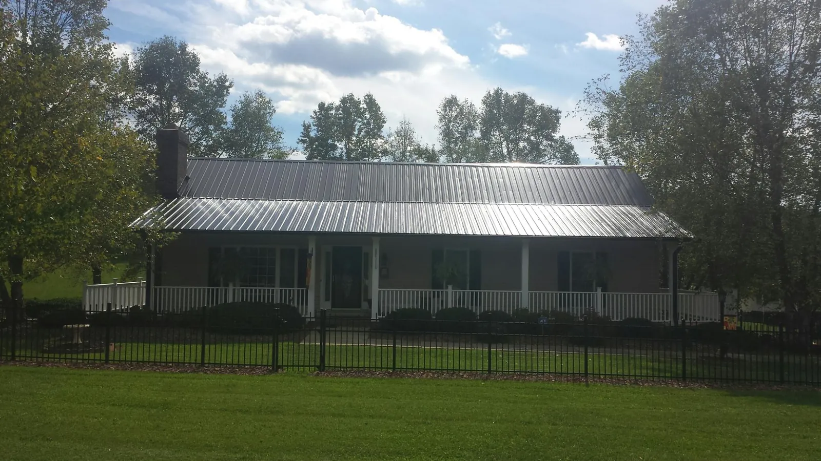 Gray metal roof on a brick ranch with a full width front porch — Gutter Guard Installation work by our crew in Dunsmuir